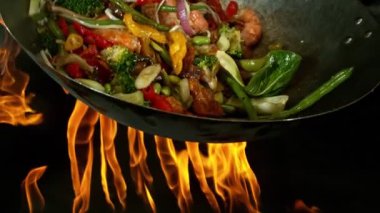 Sebze ve Etli Uçan Asya Yemeklerinin Süper Yavaş Hareketi. Yüksek Hız Sinema Kamerası 'nda çekildi, 600 fps. Kara Arkaplanda İzole Edilmiş, Alevler Yanar.