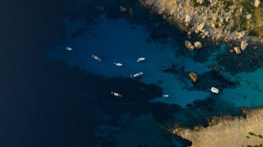 Turkuaz su ve uzun kuyruklu teknelerle dolu güzel körfezin havadan manzarası. Seyahat fotoğrafı, Mallorca, İspanya.
