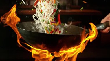 Karides ve Sebzeli Uçan Asya Yemeklerinin Süper Yavaş Hareketi. Yüksek Hız Sineması Kamerası 'nda çekildi, 1000 fps, Kamera Harekette. Arka planda Görüntü Mutfağı İçi Alevler Yanar.