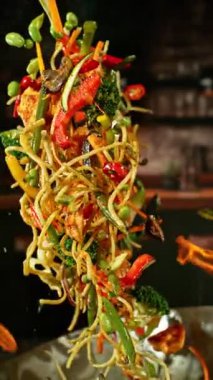 Et ve sebzeli Uçan Asya Yemeklerinin Süper Yavaş Hareketi. High Speed Cinema Camera 'da çekildi, 1000 fps. Arka plandaki Görüntü Mutfağı. Dikey Görünüm Oranı. Hız Rampası Efekti.