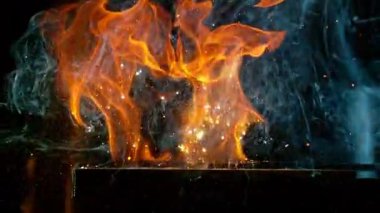 Demircinin sinematik yakın çekimi örsün üzerinde kıvılcımlar uçuşurken kızgın demir dövmesi. Karanlık arka planda dramatik ışıklandırma ile yüksek hızlı kamera ile 300 fp 'de çekildi. Hız rampası etkisi.