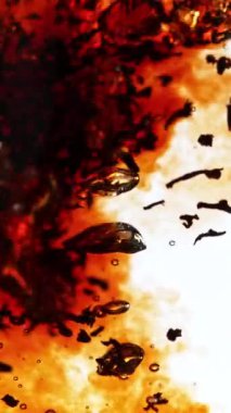 Kasırga şeklinde suya siyah çay dökmek çok yavaş bir hareket. Yüksek hızlı sinema kamerasıyla çekildi, 1000fps. Dikey görünüm oranı. Hız rampası etkisi.