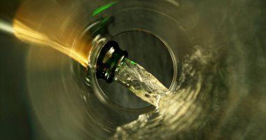 Şampanya Şarabı kadehe dökülüyor. Bardağın Altından Eşsiz Bakış Görünümü.