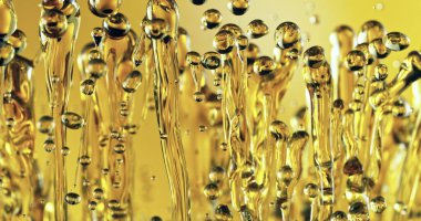 Soyut Yağın Dondurucu Hareketi Altın Arkaplanda Su Sıçratıyor. Yağ Damlaları havada uçuşuyor. Güzellik, Serum, Yakıt veya Kızartma Konsepti.