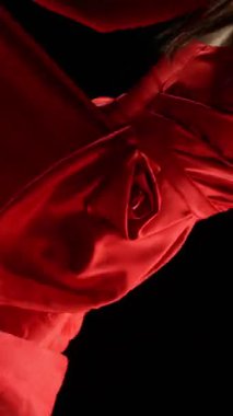 Yakut kırmızısı elbiseli çarpıcı siyah saçlı kadın ve yüksek topuklu zarif siyah arka plan pozu, Süper Yavaş Çekimde Yakalandı. Kamera Döndürme. Hız Rampası Etkisi. Dikey Görünüm Oranı.