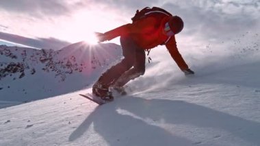 Piste Snowboardcusu 'nun orada. Süper Yavaş Hareket, 1000 fp. Avusturya 'nın Avrupa Alp Dağları' nda açık mavi gökyüzü ile güneşli bir günde Piste yamacında snowboard yapmak. Hız Rampası Efekti.
