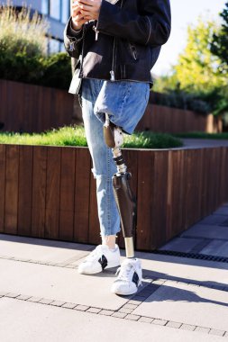 Şehirde kalan protez bacaklı genç bayana yakın çekim. Protez bacaklı bir kadın. Bacak protez ekipmanı olan bir kadın..