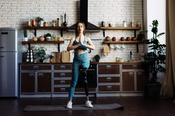 Woman with leg prosthesis performs yoga pose exuding confidence. Lady with disability finds solace and balance in yoga practice showing inner strength
