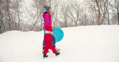Anne ve küçük çocuk kışın karda eğleniyorlardı. Kış tatili eğlence kızak binme konsepti.