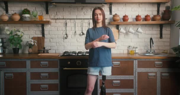 Brunette Vrouw Met Kunstmatige Ledematen Staat Keuken Met Gekruiste Armen — Stockvideo