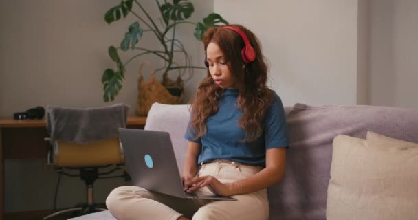 Wanita Hispanik Dengan Earphone Bekerja Pada Laptop Duduk Sofa Latin — Stok Video