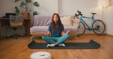 Latin Amerikalı kadın evde nilüfer çiçeği pozu vererek nefes alıyor. Düşünceli İspanyol bayan oturma odasında yoga eğitimini seviyor. Karışık ırk toleransı