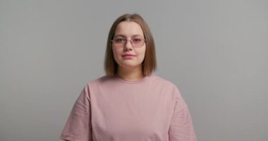 Mutlu gülümseyen genç sarışın ve iri yarı bir kadının gri duvar arkasında yalnız poz verişi. Boşluğu kopyala