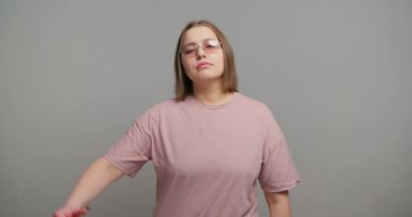 Hayal kırıklığına uğramış bir kadın, açıkça baş parmağıyla yavaş hareket ettiğini gösteriyor. Kadın öğrenci, beden dili ile tatmin olmamayı güçlü bir şekilde iletir.