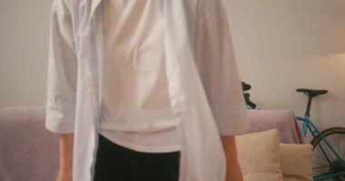 Kızıl saçlı, bitkin bir kız evdeki kanepede oturuyor. Yorgun kadın ifadesi, dinlenme anının tadını gün be gün yumuşatıyor.