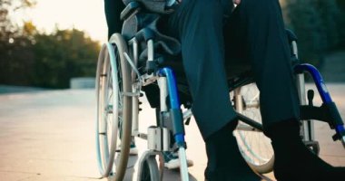 İspanyol adam tekerlekli sandalyedeki engelli arkadaşla ilgileniyor. Arkadaşlar sonbahar parkında birlikte vakit geçiriyorlar. Sağlık sigortası, sakatlık, hareket kabiliyeti, arkadaşlık. 4km 'lik atış..