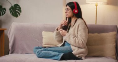 Kulaklıklı genç kadın video konferansına katılıyor. Gevşek saçlı İspanyol kadın evden tabletle online yönetim kurulu toplantısı düzenliyor.