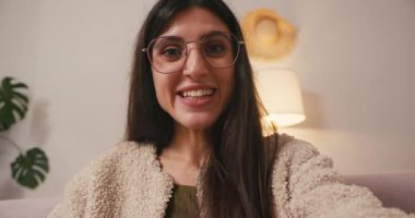 Neşeli genç kadın evden gelen video mesajlarını kaydediyor. Uzun saçlı İspanyol kadın sosyal medyada kişisel güncellemeleri yakaladı.