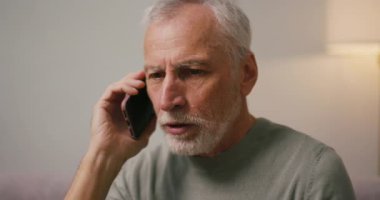 Sinirli, olgun bir Arap koltukta telefonla konuşuyor. Gri saçlı son sınıf öğrencisi hoş olmayan sohbetlerde negatif duygular gösterir.
