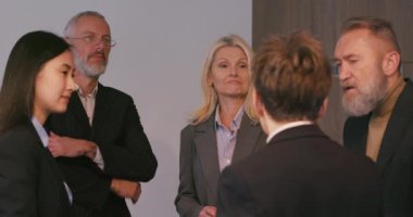 Muhtelif iş adamları ofiste toplantı sırasında iletişim kurar. Çok ırklı takım üyeleri toplantı odasında proje fikirlerini tartışmada işbirliği yapıyorlar