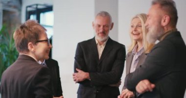 Muhtelif iş adamları ofiste toplantı sırasında iletişim kurar. Çok ırklı takım üyeleri toplantı odasında proje fikirlerini tartışmada işbirliği yapıyorlar