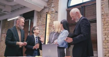 Çeşitli iş adamları ofiste canlı sohbetler yaparlar. Kahve molası sırasında toplantı odasında duran gülümsemeyle iş ekibi düşüncelerini paylaşıyor.