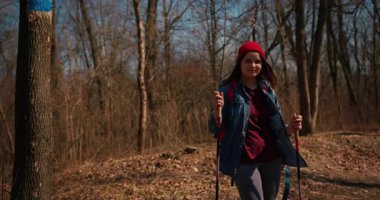 Dağ ormanlarında ağaçların arasında yürüyüş direkleri olan gezgin bir kız. Ormandaki İspanyol ergen.