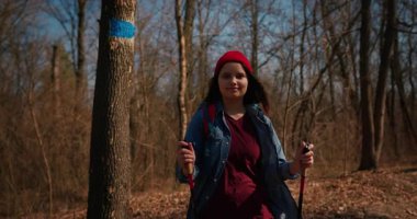 Dağ ormanlarında ağaçların arasında yürüyüş direkleri olan gezgin bir kız. Ormandaki İspanyol ergen.