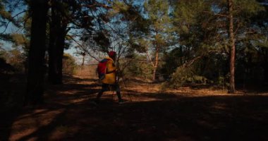 Dağ ormanlarında ağaçların arasında yürüyüş direkleri olan gezgin bir kız. Ormandaki İspanyol ergen.