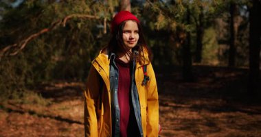 Dağ ormanlarında ağaçların arasında yürüyüş direkleri olan gezgin bir kız. Ormandaki İspanyol ergen.