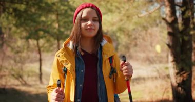 Dağ ormanlarında ağaçların arasında yürüyüş direkleri olan gezgin bir kız. Ormandaki İspanyol ergen.