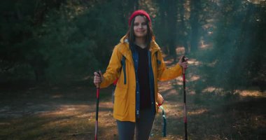 Dağ ormanlarında ağaçların arasında yürüyüş direkleri olan gezgin bir kız. Ormandaki İspanyol ergen.