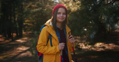 Dağ ormanlarında ağaçların arasında yürüyüş direkleri olan gezgin bir kız. Ormandaki İspanyol ergen.