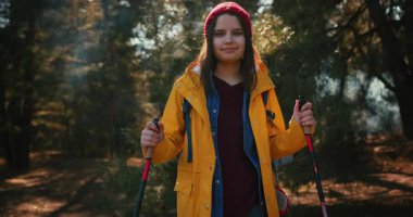 Dağ ormanlarında ağaçların arasında yürüyüş direkleri olan gezgin bir kız. Ormandaki İspanyol ergen.