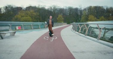 Son sınıf öğrencisi, Electric Mono Wheel Gyro Scooter 'a biniyor. İnsanlar Ekolojik Elektrik Taşımacılık Aracı Kendi Dengeleme Tekerleği.