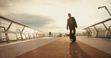 Sunrise 'da son sınıf öğrencisi Electric Mono Wheel Scoro Scooter Kişisel Elektrik Taşımacılığı. İnsanlar Ekolojik Elektrik Taşımacılık Aracı Tekerleği Kullanıyor.