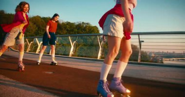 Gündelik giysiler içinde çok kültürlü kadınlar paten kayıyor. Güneşin doğuşunda eğlenirken Güzel Arkadaşların Dönüşü ve Dönüşü 'nü Uydur. Fitness Gençlik Kültür Çeşitliliği.