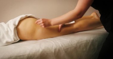 Spa Salonunda Yatan ve Kalça Masajı Yapan Mutlu Genç Kadın. Kozmetik uzmanı, lenfatik drenaj ve kaldırma efekti için popoya masaj yapıyor. Güzellik, Cilt Bakımı.