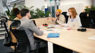 Çeşitli profesyoneller şirket ofisindeki masada oturarak işbirliği yaparlar. Çok ırklı çalışanlar şirket toplantısı sırasında iş belgeleriyle çalışırlar