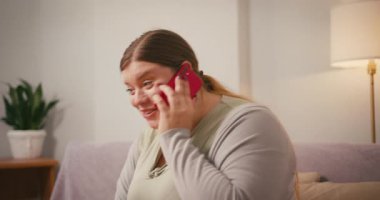 Şişman kadın, erkek arkadaşıyla konuşurken telefonu kulağına dayıyor. Kadın çok güler ve enerjik bir şekilde konuşur.