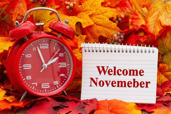 メモ帳にようこそ11月のメッセージ目覚まし時計と秋の葉 — ストック写真