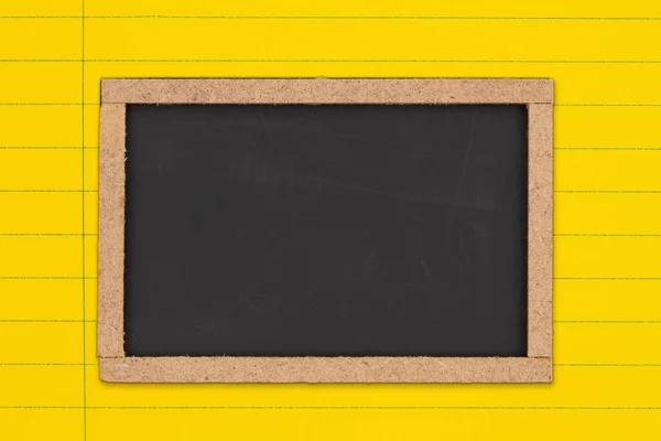 あなたの教育や学校のメッセージのための明るい黄色の支配ラインノートブックの紙の背景に空白の黒板 — ストック写真
