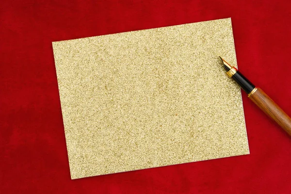 在红色毛绒材料上涂上空白贺卡 并配上钢笔 以传达节日信息 — 图库照片