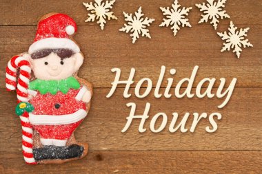 Holiday Hours message with cute gingerbread elf on weathered wood with snowflakes clipart