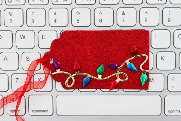 あなたの休日のオンラインショッピングメッセージのためのキーボードの空白の赤いクリスマスライトギフトタグ — ストック写真