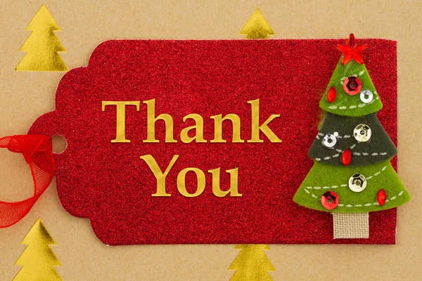 Thank You message on red holiday gift tag with a Christmas tree on gold