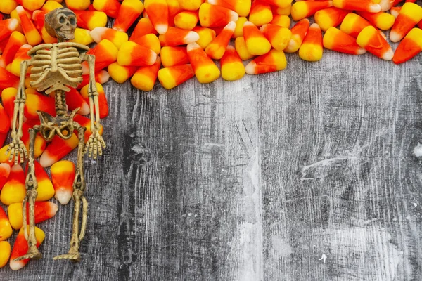 Candy corn with a skeleton Halloween background with weathered wood for you candy of holiday message