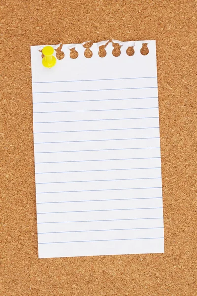 Blank ruled paper with a pushpin on a corkboard for your message or information