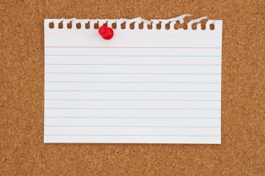 Blank ruled paper with a pushpin on a corkboard for your message or information