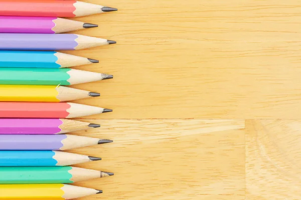 教育や学校のメッセージのための木製の机の上にパステルカラーの鉛筆の背景 — ストック写真